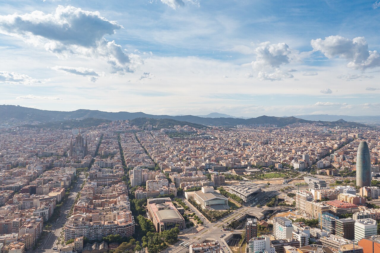 Vista aerea della griglia di strade dell'Eixample, con la Sagrada Família a sinistra e le colline di Collserola sullo sfondo