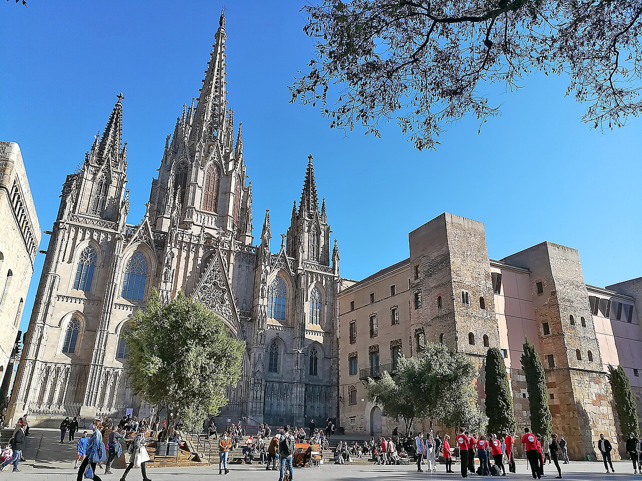 Die gotische Fassade und die Türme der Kathedrale von Barcelona von der Avinguda de la Catedral aus, rechts die Casa de l'Ardiaca und Türme der alten Stadtmauer